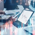 Business woman sitting front laptop computer with financial graphs and statistics on monitor. Double exposure. Wide.