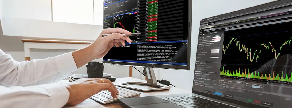 Professional trader analyzing ETF charts and market data on multiple computer screens
