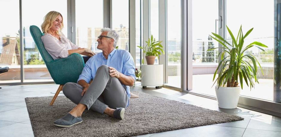 Happy middle-aged couple in modern home representing successful retirement planning