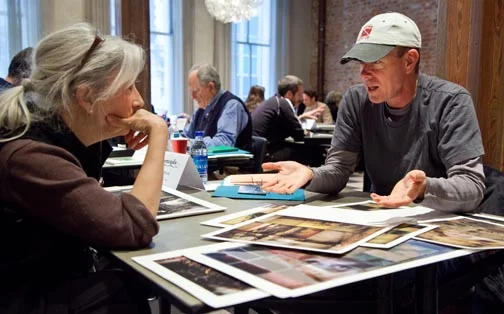 Two people engaged in an intense portfolio review discussion at a table