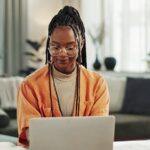 Young woman working on laptop reviewing financial information