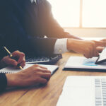 Professional working at desk with financial charts and calculator