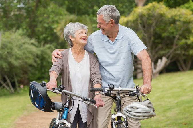 Active older couple with bicycles in park