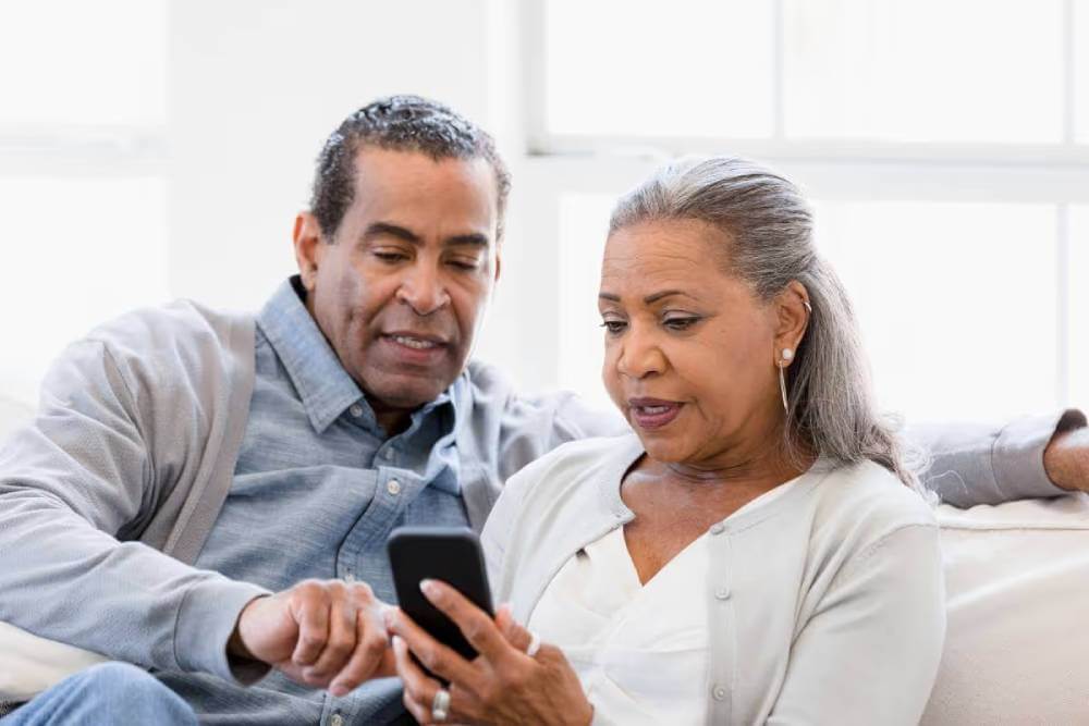 Older couple reviewing smartphone financial information together