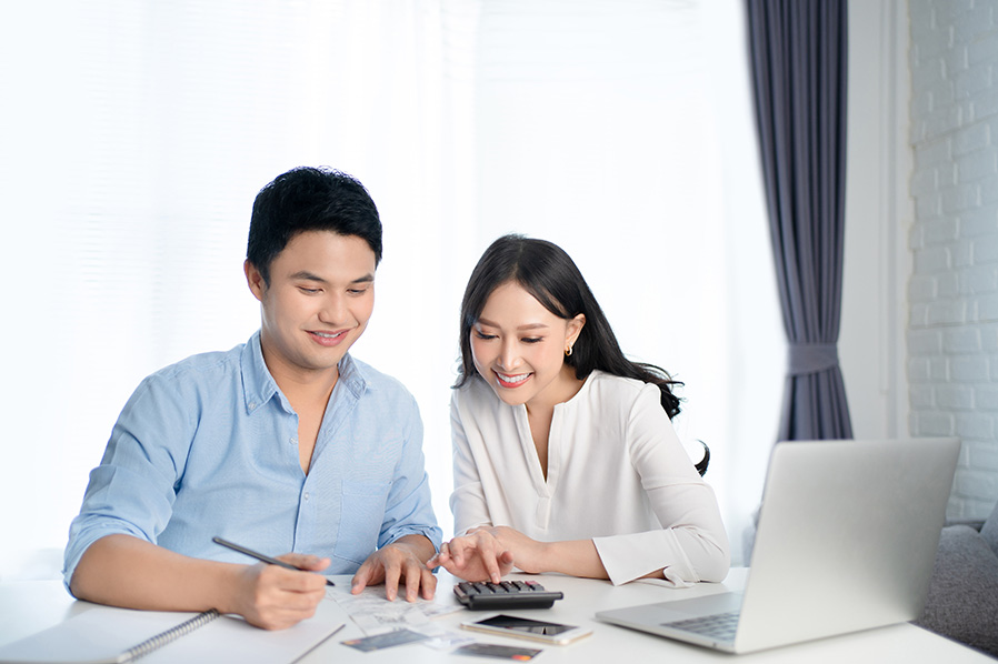 Young couple working on financial planning with calculator and documents