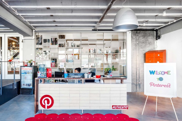 Pinterest's reception area showcasing the company's industrial-chic office design with branded elements and modern workspace aesthetics