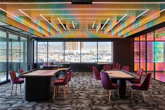 DraftKings office casino-style card room with poker tables and colorful LED ceiling lighting