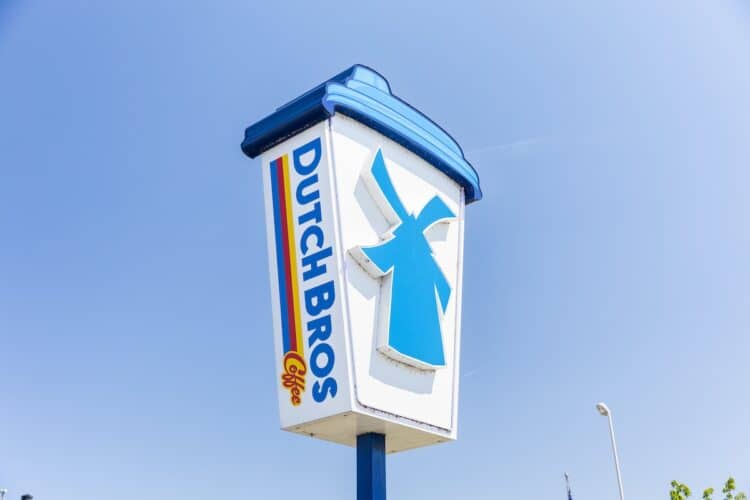 Dutch Bros iconic coffee cup-shaped roadside sign with windmill logo, symbolizing the brand's distinctive marketing and rapid market expansion