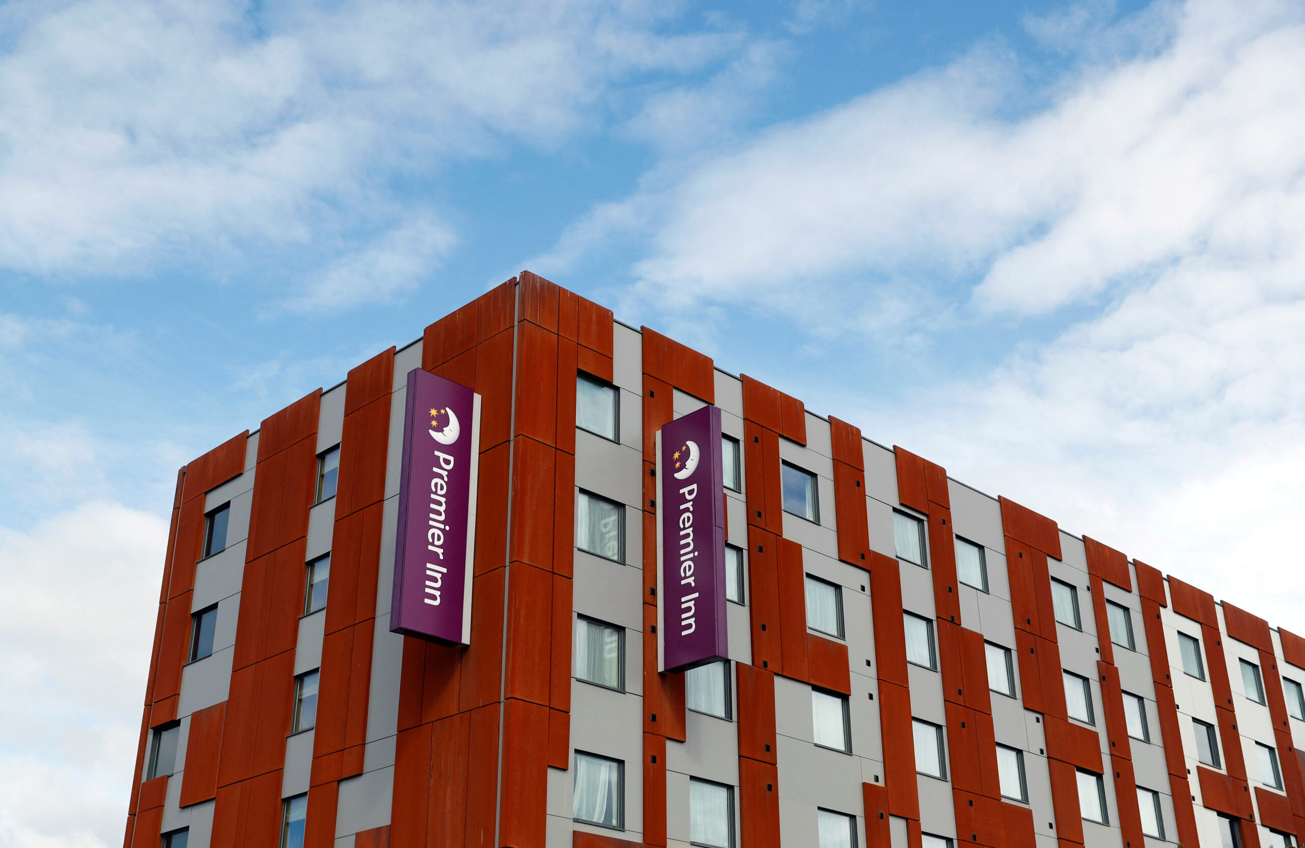Premier Inn logo displayed on the exterior of a building, photographed from below against the sky.