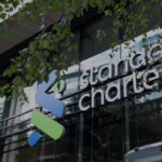 Front exterior of Standard Chartered's London office building with company signage above the entrance.