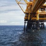 Offshore oil and gas production platform in the ocean, representing offshore E&P operations