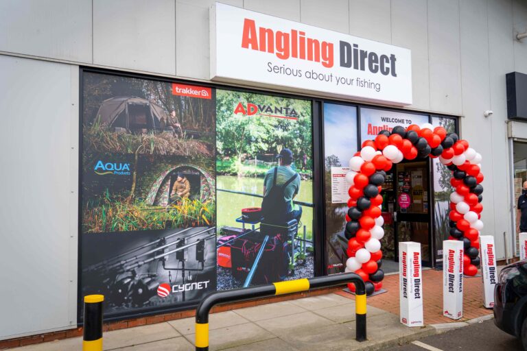 Exterior of an Angling Direct fishing tackle store with signage and a balloon arch at the entrance