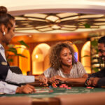 Casino dealer and two smiling customers at a blackjack table with chips, representing casino/gaming operations