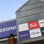 Exterior of a Shoe Zone store showing the shoezone sign and footwear brand logos on the shopfront.