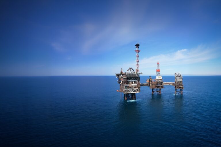 Aerial view of an offshore oil and gas platform in the North Sea under a clear blue sky
