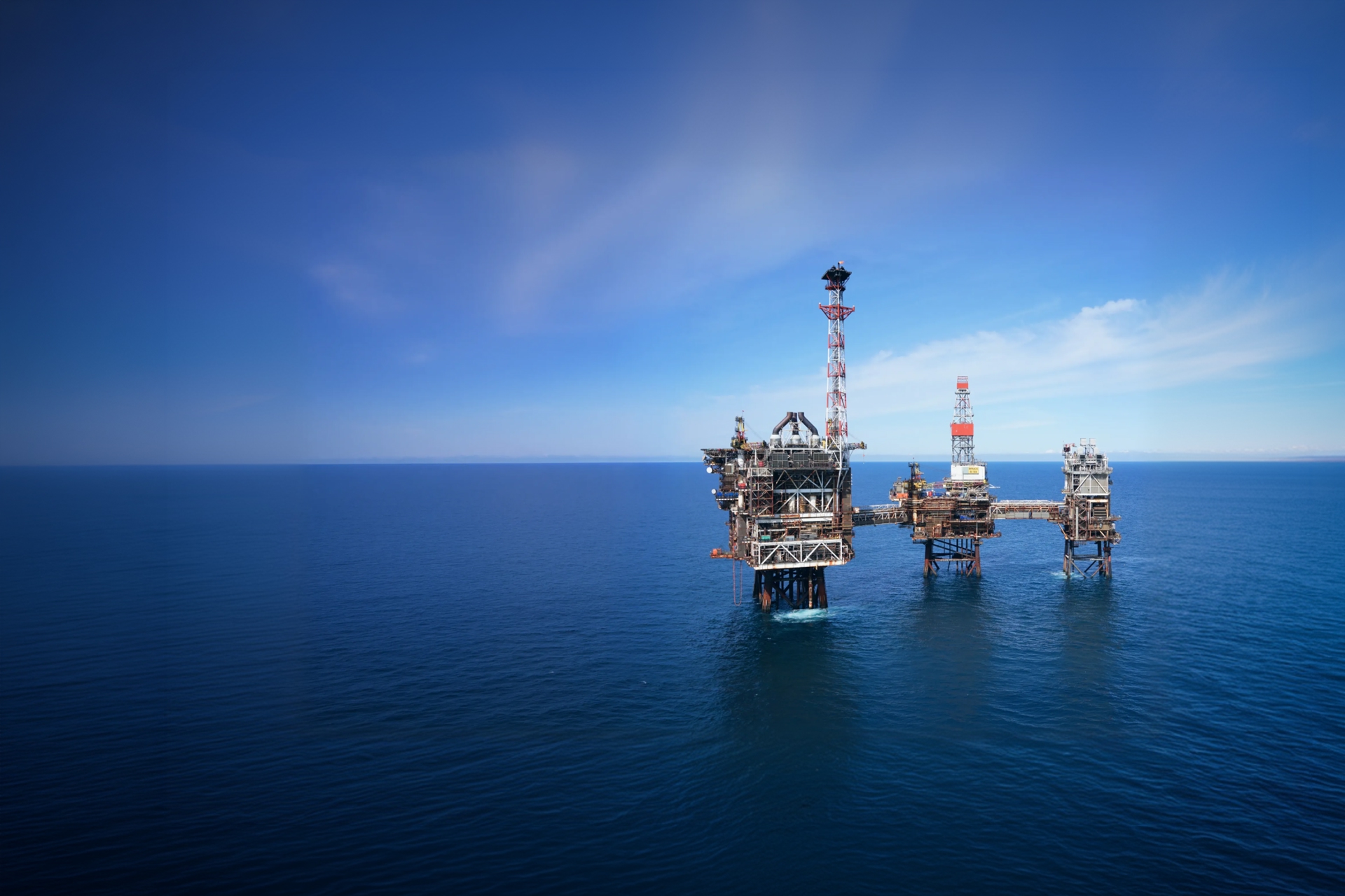 Aerial view of an offshore oil and gas platform in the North Sea under a clear blue sky