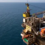 Aerial photo of the Bruce 9/9A offshore oil and gas platform with a support vessel on the horizon