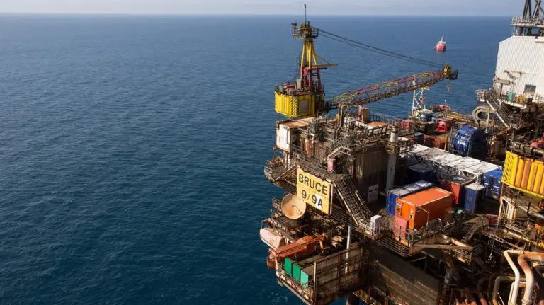 Aerial photo of the Bruce 9/9A offshore oil and gas platform with a support vessel on the horizon
