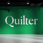 Quilter plc branded green feature wall with logo in a modern office reception area