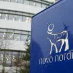 Novo Nordisk logo displayed on a building/signage, representing the pharmaceutical company amid news of profit warnings and drug pricing pressure