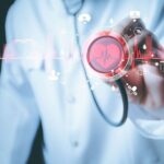 A doctor holding a stethoscope with a heart rate and cardiovascular health graphic overlay, symbolizing cardiac health testing