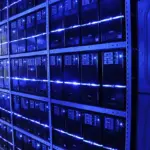 Rows of server racks with blue LED lighting inside a data centre