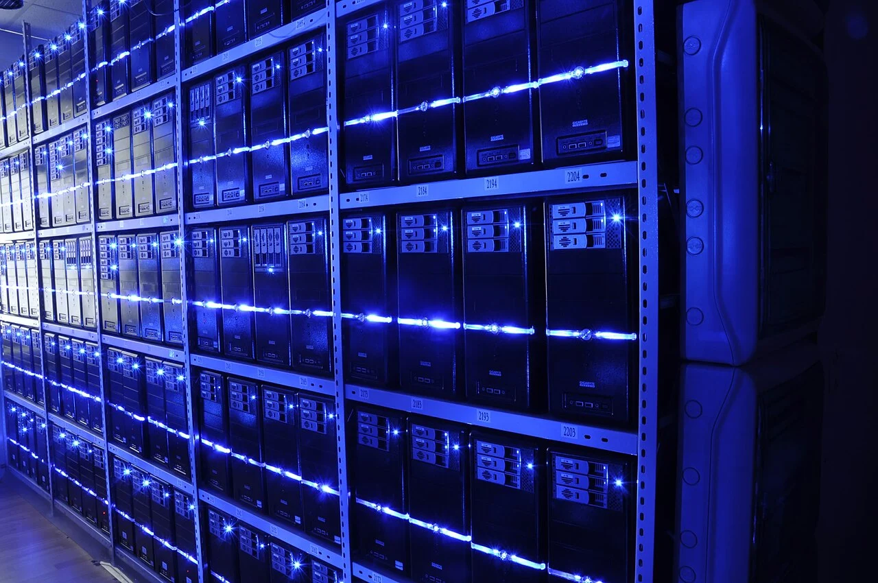 Rows of server racks with blue LED lighting inside a data centre