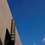Exterior view of a Debenhams store sign against a blue sky