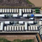 Top-down aerial view of a battery energy storage facility with organised rows of storage units, representing Gresham House Energy Storage Fund infrastructure