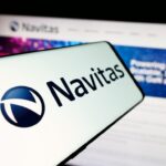 Smartphone screen showing the Navitas logo in front of a blurred Navitas Semiconductor website mentioning GaN and SiC