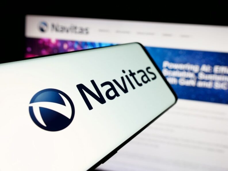 Smartphone screen showing the Navitas logo in front of a blurred Navitas Semiconductor website mentioning GaN and SiC
