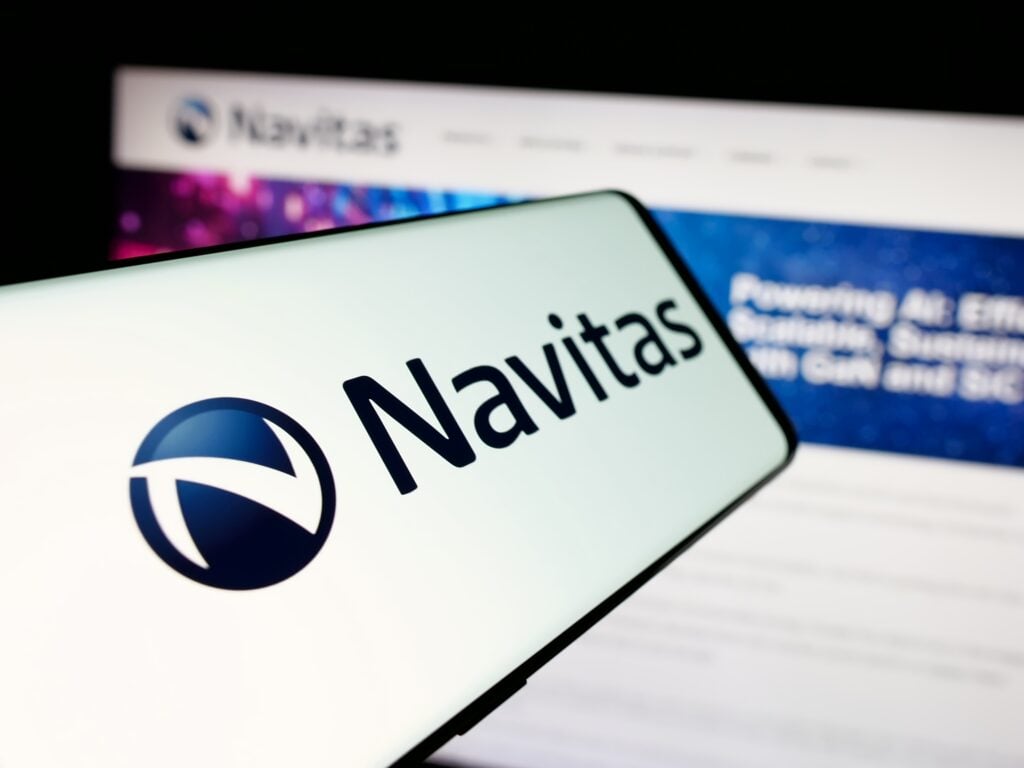 Smartphone screen showing the Navitas logo in front of a blurred Navitas Semiconductor website mentioning GaN and SiC