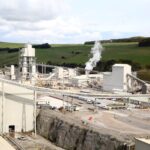 Aerial view of a lime processing plant and quarry set within green countryside hills