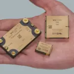 Palm holding three gold Vicor power modules: BCM6135, DCM3735 and NBM2317