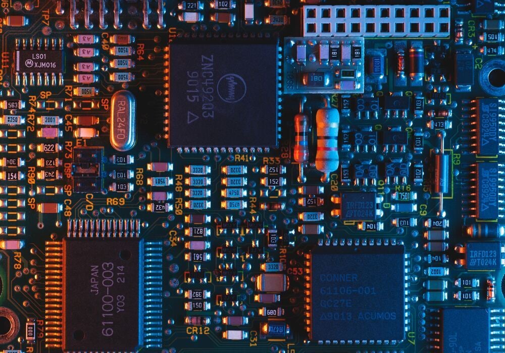 Close-up of an electronic circuit board with microchips, symbolising technology sector investment