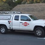 White Orkin branded pickup truck with pest control commercial services signage parked in a lot