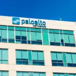 Palo Alto Networks signage mounted on the exterior of a corporate office building against a clear blue sky.