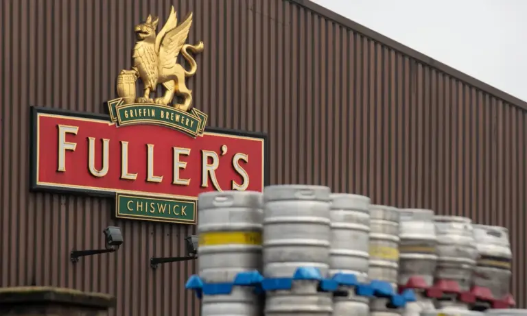 Exterior of a traditional Fuller's pub with hanging sign, on a London street.