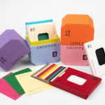Colourful James Cropper branded boxes and paper colour swatches arranged on a plain white background