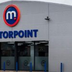Grey Motorpoint car supermarket building with large Motorpoint logo and blue lettering above the entrance