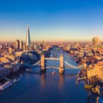 Aerial view of the London skyline at sunrise, with Tower Bridge over the River Thames and the Shard and City towers on either side