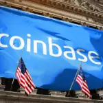 Blue Coinbase banner hanging on the New York Stock Exchange building, with American flags in front