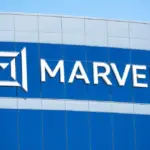 White Marvell logo and lettering mounted on a blue building facade under a clear sky